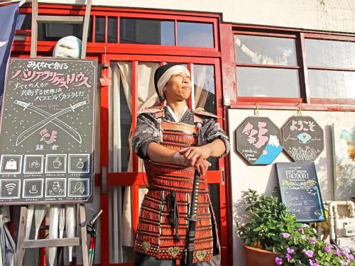 a man standing in front of a building at Guest House Irodori Kamakura in Kamakura