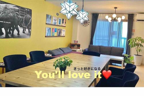 a living room with a wooden table and a room with at roundabout OSAKA in Osaka