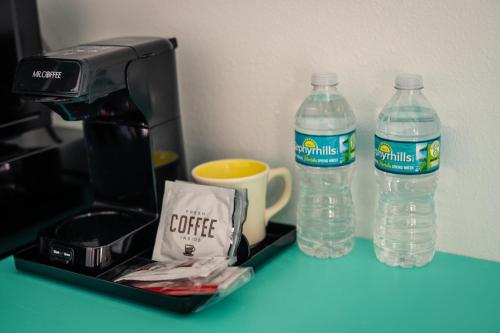 two bottles of water sitting next to a coffee maker at Salt Air Inn & Suites in Atlantic Beach
