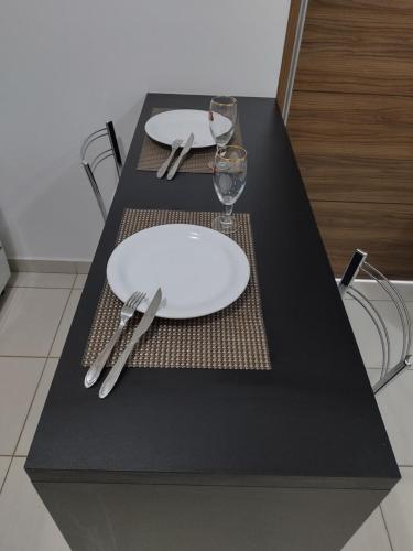 a table with a white plate and silverware on it at Aconchego Encantador in Viçosa