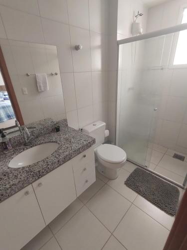 a bathroom with a toilet and a sink and a shower at Aconchego Encantador in Viçosa