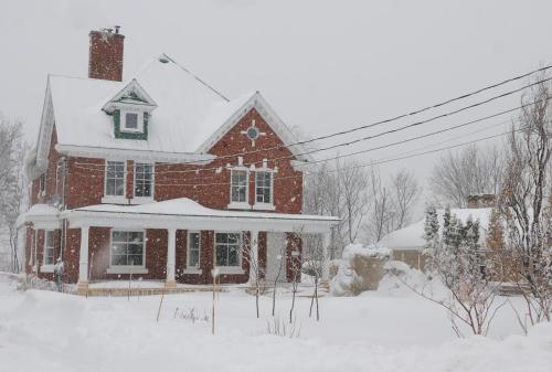 a red brick house with snow on top of it at Napier House in Campbellton