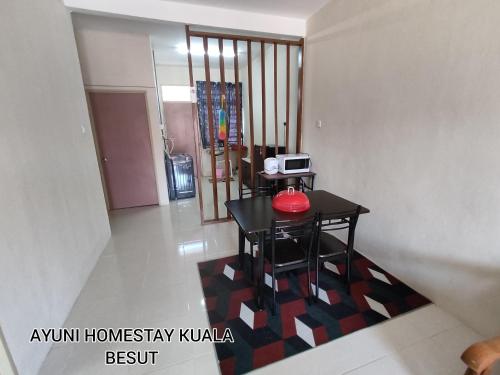 een kamer met een tafel met een rode kom op een tapijt bij AYUNI HOMESTAY KUALA BESUT TERENGGANU in Kampung Kuala Besut