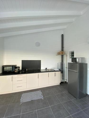 a kitchen with white cabinets and a stainless steel refrigerator at L'améthyste in Saint-François