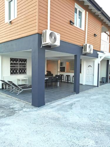a house with a patio with tables and chairs at L'améthyste in Saint-François