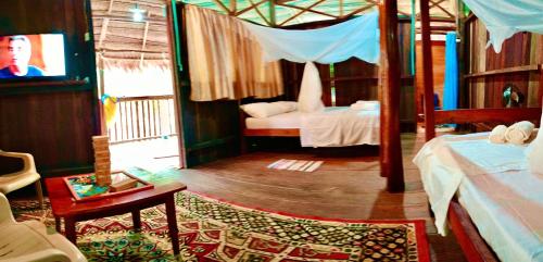 萊蒂西亞的住宿－Bungalow In The Jungle -Ecolodge HUITOTO，一间卧室配有两张床和一台平面电视