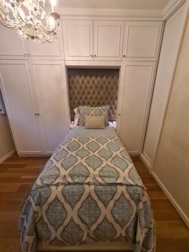 a bedroom with a bed and a chandelier at Avenida Las Heraas in Buenos Aires
