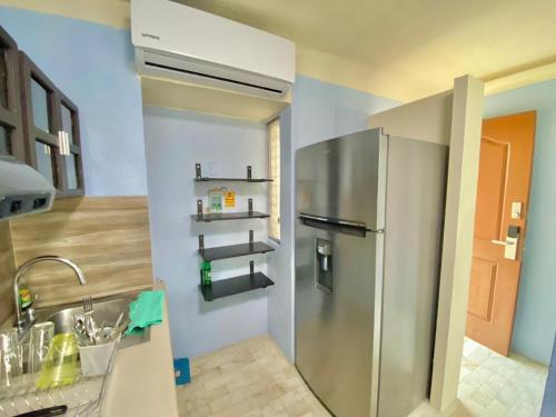 una cocina con refrigerador de acero inoxidable junto a un fregadero en estudio de hotel con playa beach frente aparmet, en Cancún