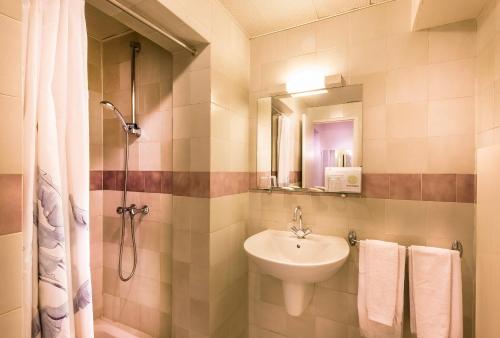 a bathroom with a sink and a shower at Hotel Le Clos d'Alésia in Paris