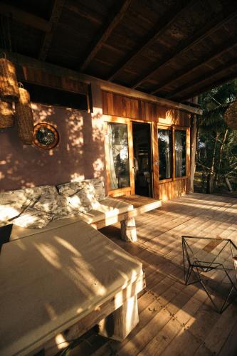 a wooden deck with a table and chairs on it at BOA BOA Bacalar in Bacalar