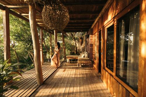 a woman walking on a porch of a house at BOA BOA Bacalar in Bacalar