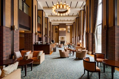 a lobby with couches and tables and chairs at Towada Hotel in Kosaka