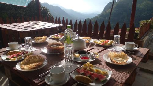 - une table remplie de nourriture avec vue sur les montagnes dans l'établissement Secret View Homestay Ella, à Ella