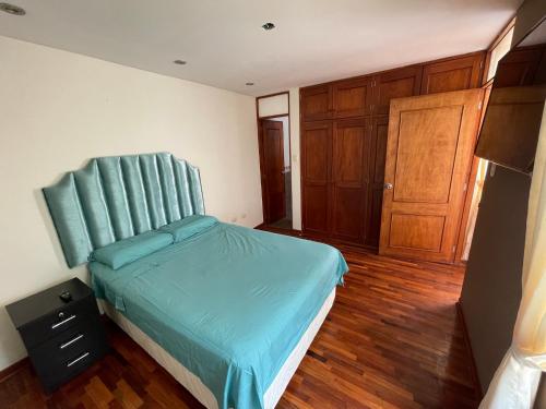 1 dormitorio con 1 cama con cabecero azul en Exclusivo Apartamento en el corazón de Trujillo en Trujillo