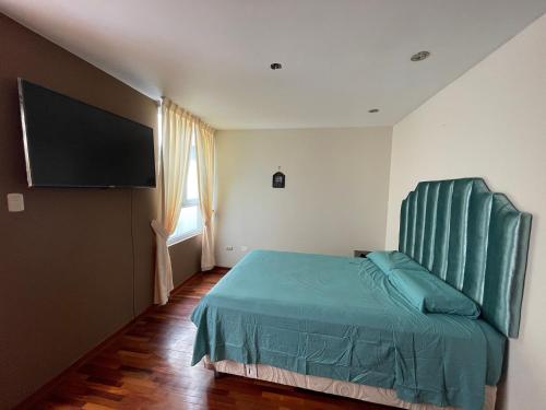 um quarto com uma cama e uma televisão de ecrã plano em Exclusivo Apartamento en el corazón de Trujillo em Trujillo