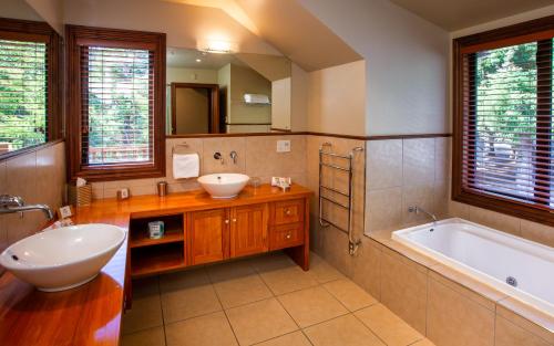 a bathroom with a tub and a sink and a tub and a bath tub at Grasmere Lodge in Cass