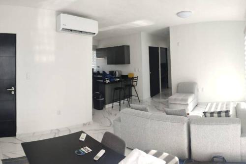 a living room with couches and a table and a kitchen at ACAPULCO DIAMANTE!! HERMOSO DEPARTAMENTO NUEVO!! in Acapulco