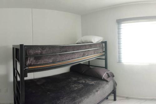 a bunk bed in a room with a window at ACAPULCO DIAMANTE!! HERMOSO DEPARTAMENTO NUEVO!! in Acapulco
