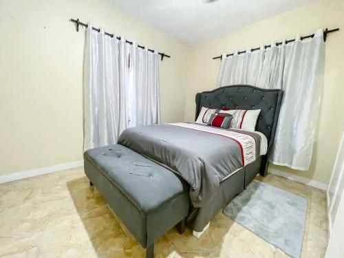 a bedroom with a bed with a bench next to it at Red Hassell Manor in Port Antonio