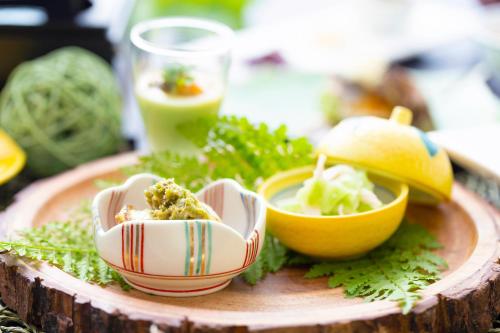 a wooden plate with bowls of food on a table at Towada Hotel in Kosaka