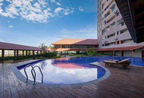 a swimming pool with a bench and a building at Oceanfront Galle by ICC in Galle
