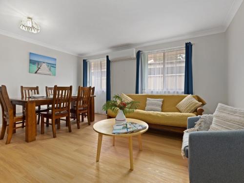 a living room with a couch and a table at Furry Friends by Experience Jervis Bay in Sanctuary Point