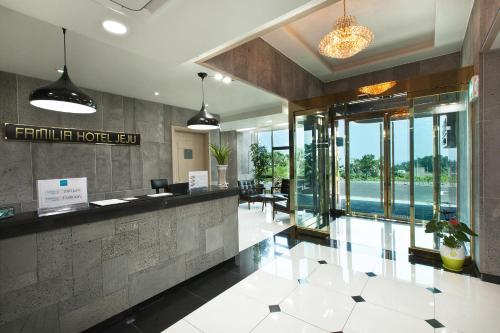 a lobby of a hotel with a reception counter at Familia Hotel in Seogwipo