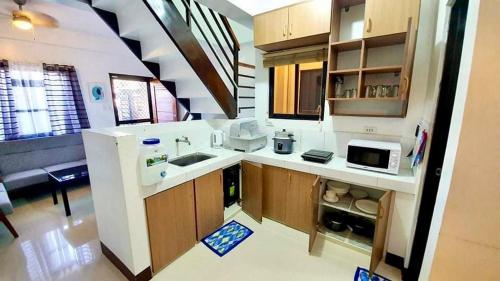 a large kitchen with a sink and a microwave at Kaitleen Home Stay Door 2 in Tacloban