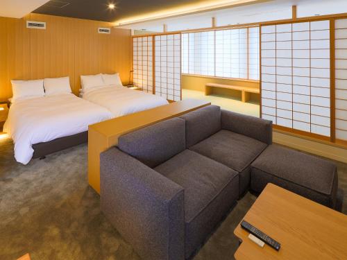 un soggiorno con letto e divano di Hotel Muso a Kyoto