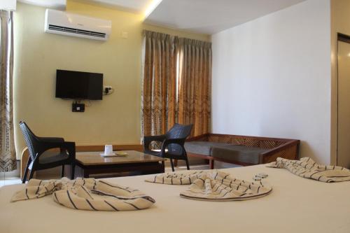 a hotel room with two beds and a living room at Annai in Saravana Bhavan Fine stay and Restaurant in Velānganni