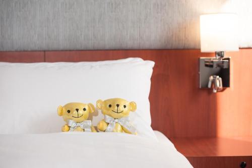 two teddy bears sitting on top of a bed at B P International in Hong Kong