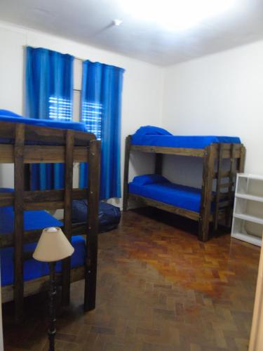 two bunk beds in a room with blue curtains at Casamundocba in Cordoba