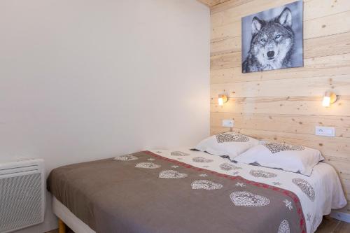 a bedroom with a wolf picture on the wall at méd in Les Menuires
