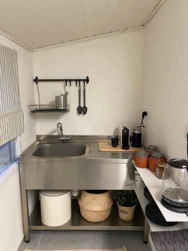 a kitchen with a sink and a counter with pots and pans at תל שיבן אירוח בשעל in Sha'al