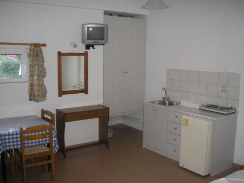 cocina con fregadero, mesa y espejo en Dimitra Apartments, en Gouves