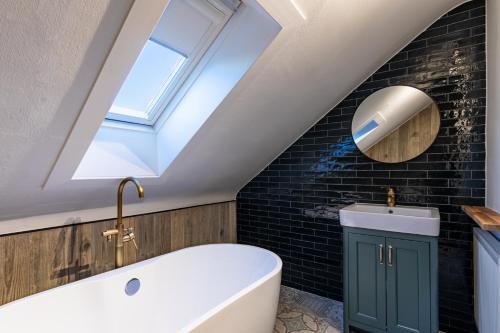 a bathroom with a skylight and a white bath tub at The Nessting Place in Inverness