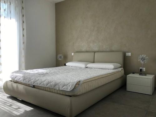 a bedroom with a large bed with white sheets at Super Villa With Private Pool in Isola Albarella in Isola Albarella