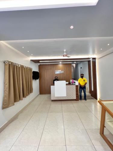 a man standing at a reception desk in a room at Darshan Executive in Kolhapur