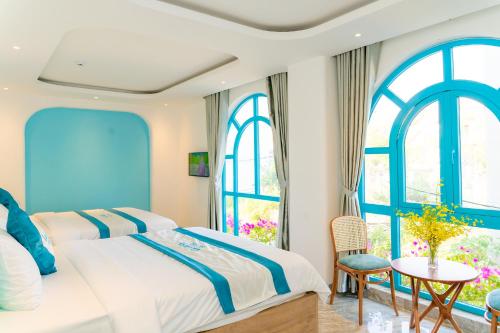 a bedroom with two beds and a table and chairs at La Casa Boutique Hotel in Vung Tau