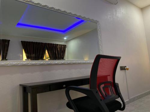 a red chair in front of a mirror at Tokman Inn in Pantai Cenang