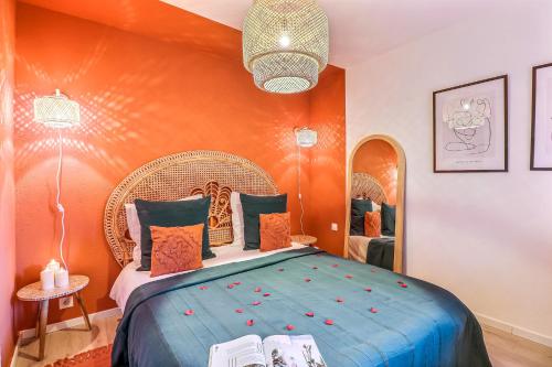 une chambre avec un grand lit avec un mur orange dans l'établissement La Vermeillade Appartement Privé, à Congéniès