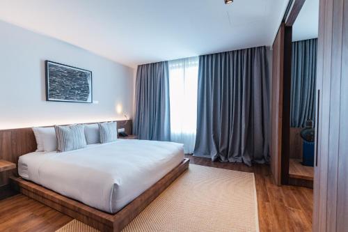 a bedroom with a large white bed and a window at QUU HOTEL Chiang Mai in Chiang Mai