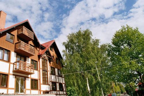 a large building with trees in front of it at Kantal Apartamenty Hel in Hel