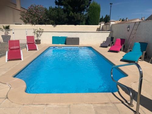 - une piscine avec des chaises colorées dans l'établissement La Matriola, à Cabannes