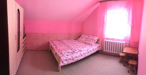 a pink bedroom with a bed and a window at У Ондраша in Yasinya