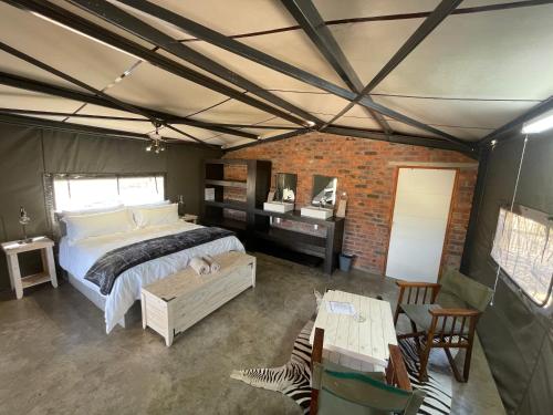 una camera con un grande letto in una tenda di Newburg Lodge & Luxury Bush Tents, Elements Private Golf Reserve a Moheme