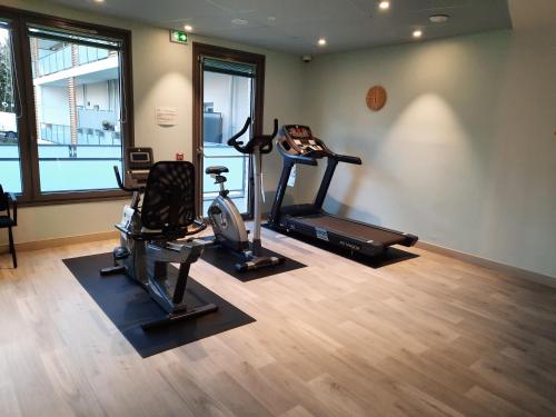 a gym with two treadmills and two exercise bikes at DOMITYS - Le château de la Pilule in Saint-Quentin