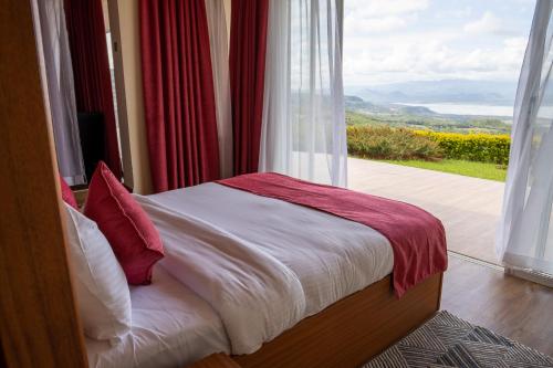 a bed in a room with a large window at Lake Elementaita Mountain Lodge in Nakuru