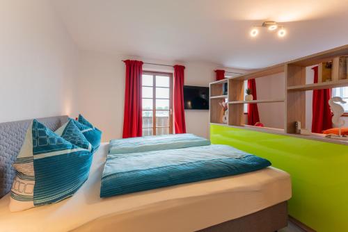 sypialnia z łóżkiem w kolorze niebieskim i zielonym w obiekcie Jakobos Tapasbar w mieście Eggstätt