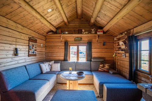 une chambre avec un canapé et une table dans une cabine dans l'établissement Olestølen, à Skammestein